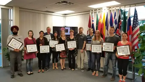 Cohort of START Canada alumni holding framed completion certificates